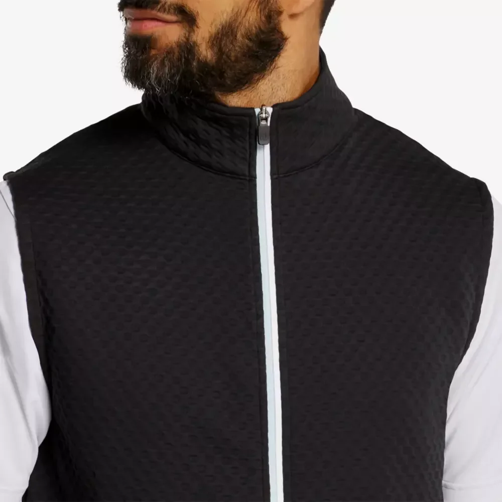 A man with a beard wearing a textured, dark-colored zip-up vest over a white long-sleeve shirt, shown from the shoulders up—perfect attire for those seeking the best golf deals for $100 or less.