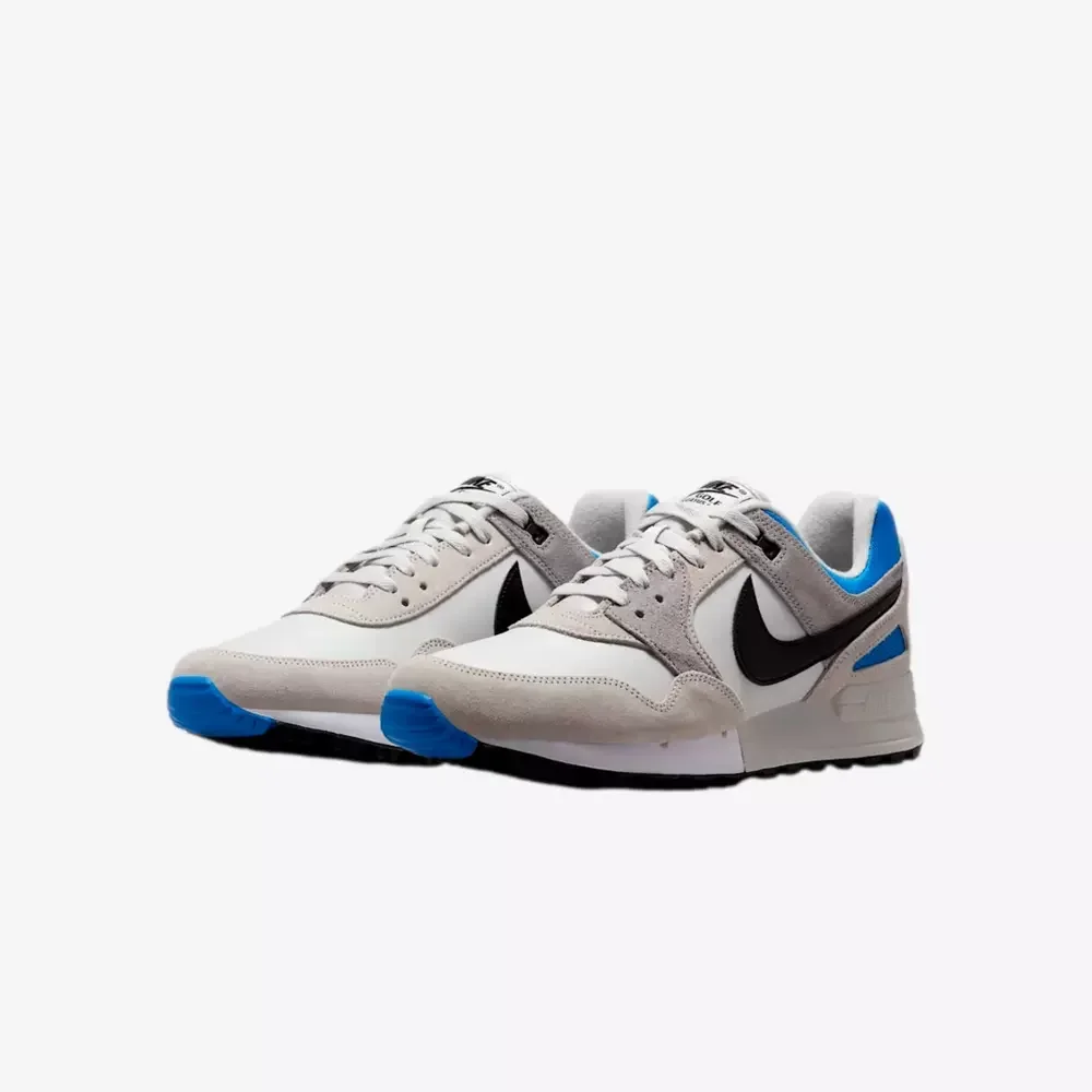 A pair of white athletic sneakers with black Nike swooshes, blue accents on the soles and heels, and gray detailing, displayed on a plain white background—shop the best deals under $50.